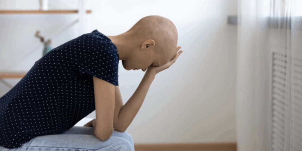 A woman holding her head in thought, symbolizing chemo brain or cognitive changes after chemotherapy.